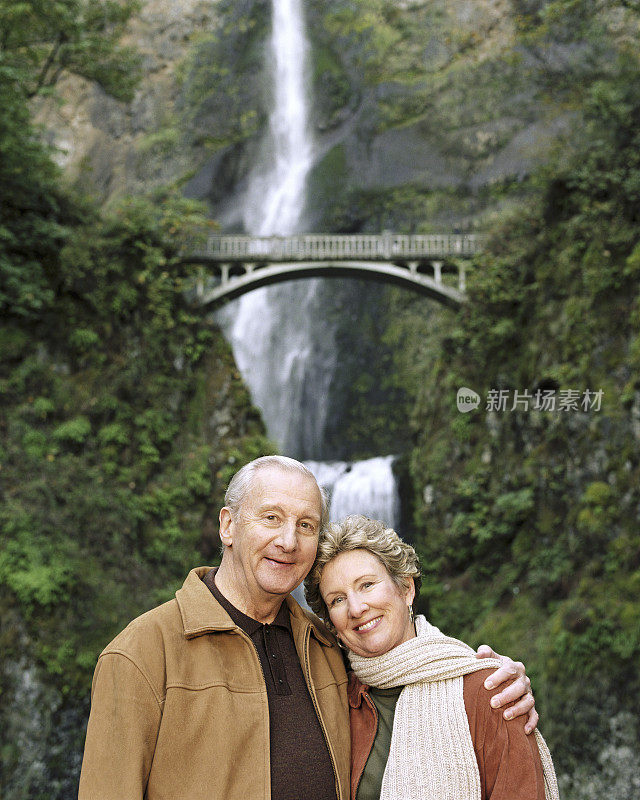 美国，俄勒冈州，一对微笑的成熟夫妇，背景是Multnomah Falls